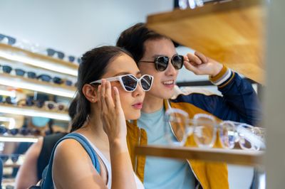 Shoppers trying on sunglasses